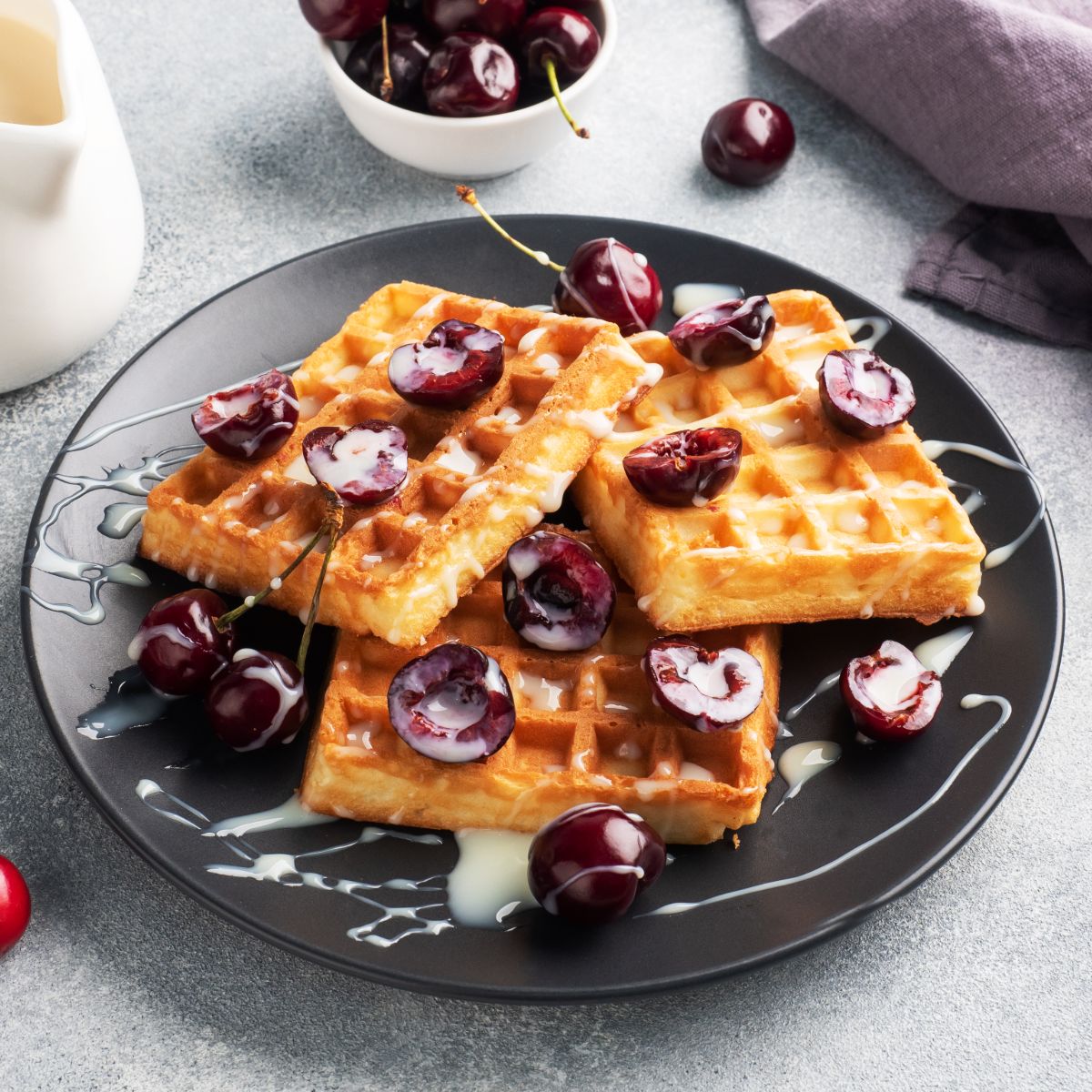 belgian-waffles-with-fresh-cherries-and-cream-on-a-plate.jpg